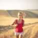 A woman jogging through vast, golden wheat fields under the summer sun, symbolizing freedom and adventure.